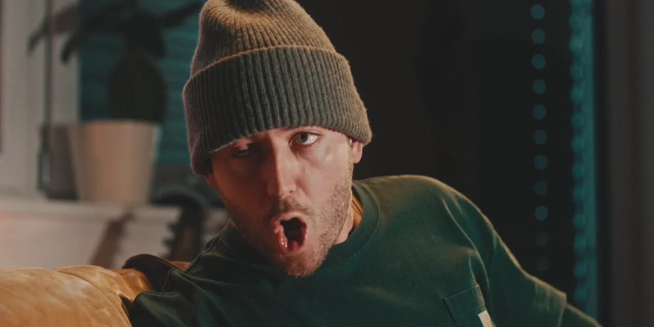 Close-up of comedian Austrian Kiwi performing as an Austrian during the high-stakes phone call scene, showcasing expressive character acting.