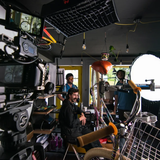 Wide behind-the-scenes view of the Holy Moly Films set inside a unique bicycle upcycling shop in Salzburg.