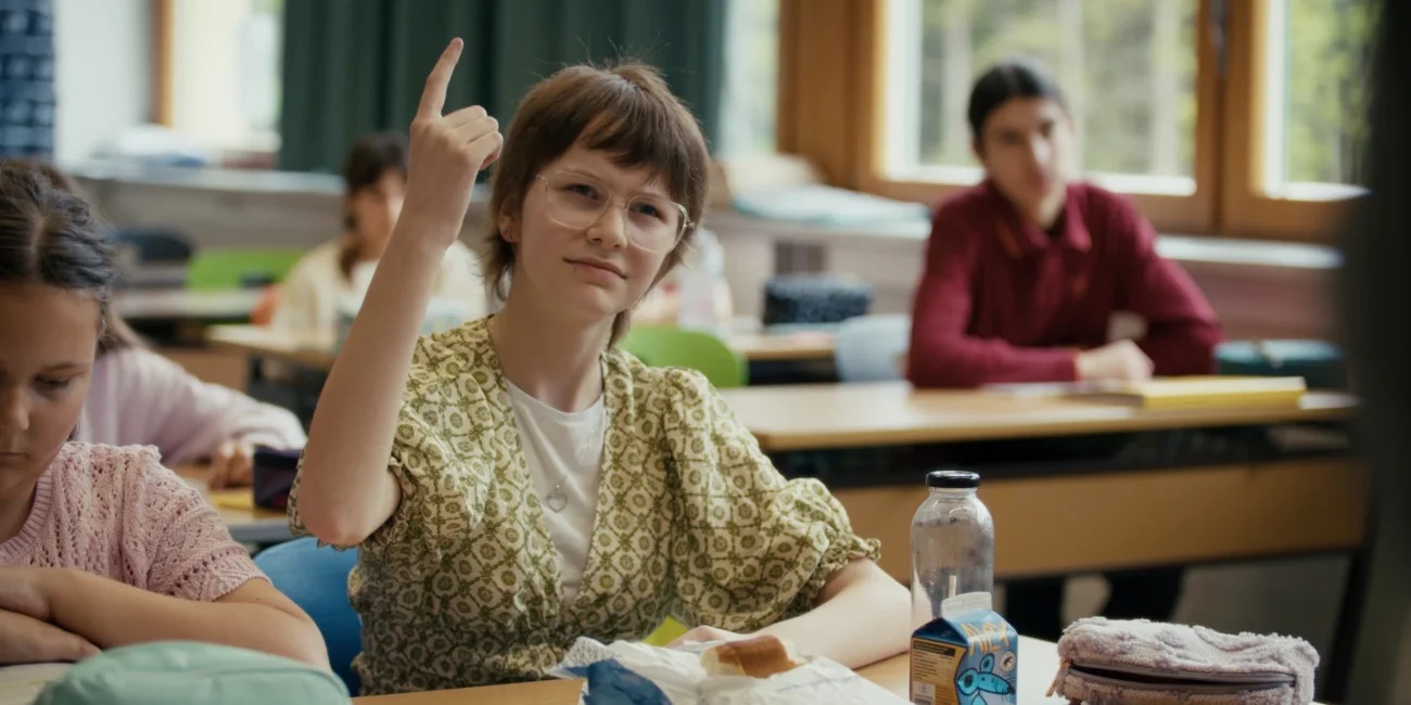 A close-up reaction shot of a student looking visibly confused by the teacher's incorrect English pronunciation.