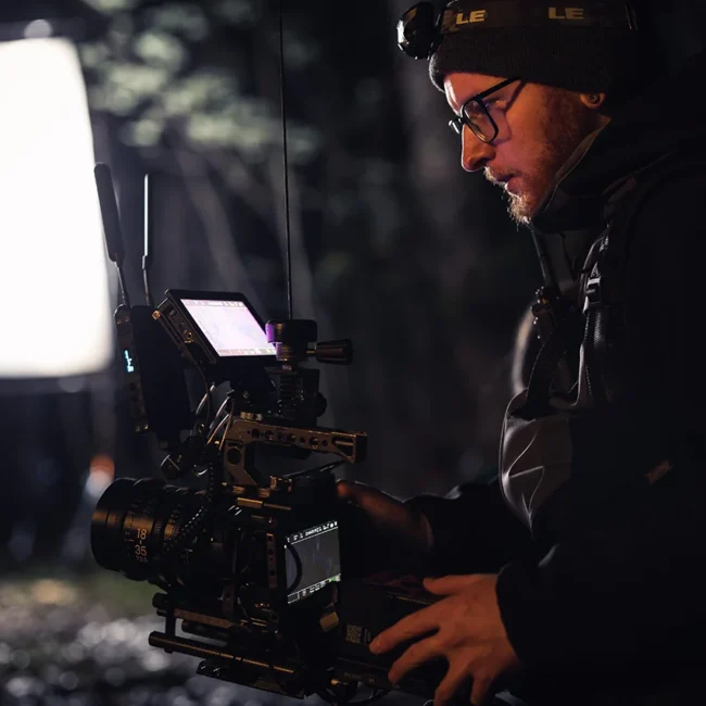 Director of photography Imanuel Thallinger operating a fully rigged cinema camera during a night shoot.