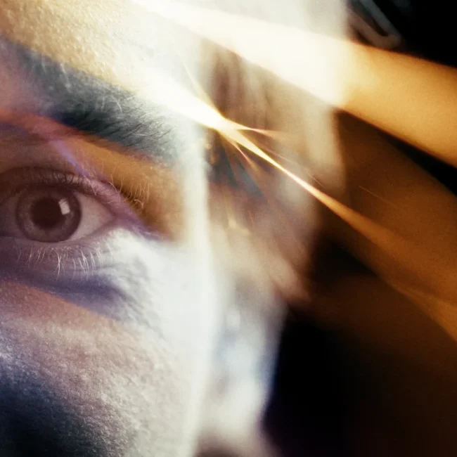Close-up of an eye behind reflective lighting effects during the video production for Perwein and Naked Optics by Holy Moly Films.